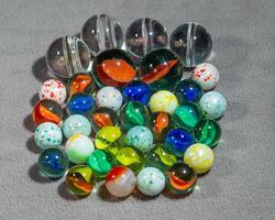 a collection of various types and sizes of marbles grouped together photo