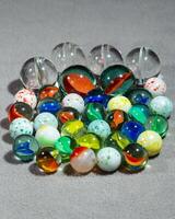 a collection of various types and sizes of marbles grouped together photo