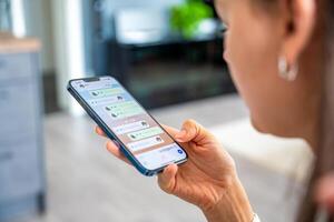 Prague, Czech republic - May 2, 2024. Woman holding iPhone with chat application WhatsApp on the screen, using mobile application for voice messaging at home. High quality photo