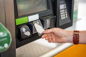 Close up view of man hand pays for fuel with a credit card on terminal of self-service filling station in Europe photo