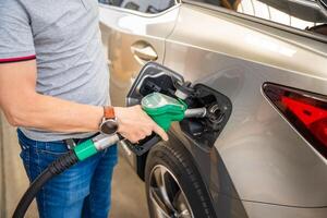 el conductor llena arriba costoso gasolina en autoservicio relleno estación en Europa foto