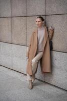 Young beautiful woman wearing coat walking in the city centre of Prague, Czech republic, Europe photo