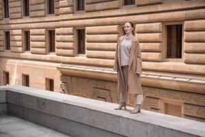 Young beautiful woman wearing coat walking in the city centre of Prague, Czech republic, Europe photo