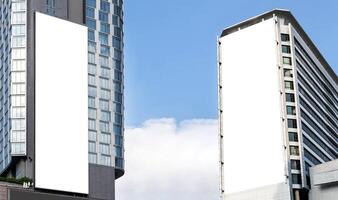 Two outdoor vertical billboard on building with blue sky background photo