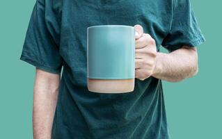 Man hand hold green coffee cup isolated on green background with clipping path photo