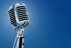 Silver retro microphone isolated on blue background photo