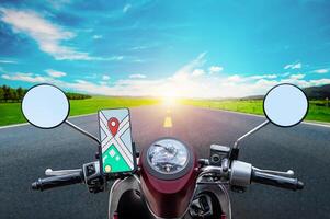 Navigate map on display smartphone on handle bar motorcycle with highway road view background photo