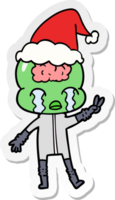 hand drawn sticker cartoon of a big brain alien crying and giving peace sign wearing santa hat png