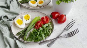 färsk vår sallad med kokt ägg, sparris, och tomater på en ljus dag video