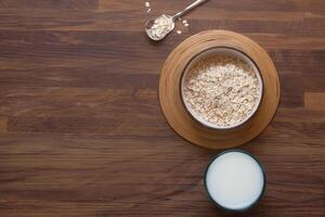 alto ángulo ver de avena copos y Leche en mesa foto