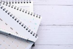 stack of calendar and pen on office desk photo