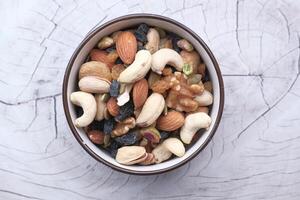 Mixed nuts in wooden bowls on wooden table . photo