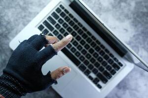 hacker mano robando datos desde ordenador portátil a noche foto