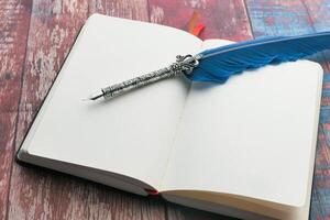 notepad with fountain pen on wooden background photo