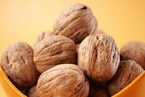 natural walnut in a bowl on yellow background photo