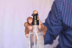 young man with casual dress using hand sanitizer for preventing virus photo