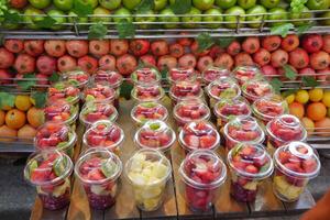 pineapple, kiwi and Strawberries in. plastic container selling at shop photo