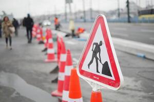 traffic sign on street with construction site photo