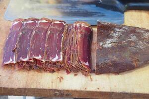 turco carne pasturma en un el cortar tablero , seco carne en un plato foto