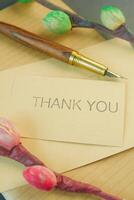 thank you message and envelope on wooden table photo