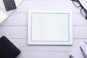 digital tablet with blank screen on wooden background photo