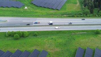 Drone flight on a German highway with lots of traffic and large solar panels next to the road. video