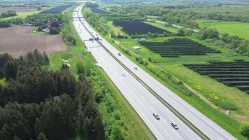 Drone flight on a German highway with lots of traffic and large solar panels next to the road. video