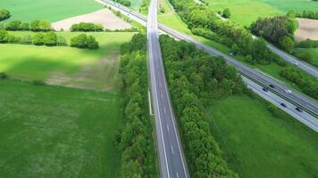 Drönare se av en motorväg i Tyskland med en massa av trafik och många grön fält runt om Det. video