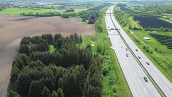 Drone view of a highway in Germany with a lot of traffic and many green fields around it. video