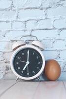 alarm clock and egg on table with copy space. photo