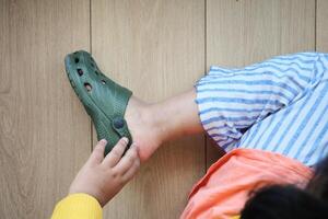 little girl feet trying to remove her sandal photo