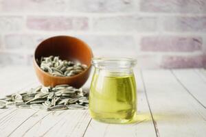 sunflower oil seed and oil in a container on table photo