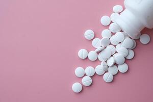 white pills spilling on pink background, Top view photo