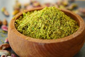 Wooden bowl filled with pistachios flour, a natural and nutritious superfood photo