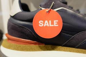 Men sneaker with red sale sign displaying on shelf photo