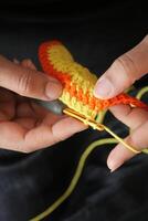 Hand close up crocheting with a hook, wool yarn, creative craft photo