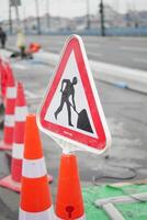 Man walking by traffic sign on street with construction site photo