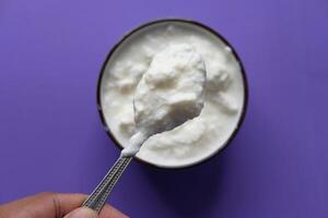 close up of fresh yogurt in a bowl on color background photo