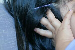 child having ear pain touching his painful ear , photo