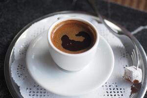 a cup of turkish coffee and a delight on table photo