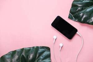 smart phone and earphone on pink background . photo