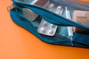 thermometer, pills and blister pack in a medicine bag photo