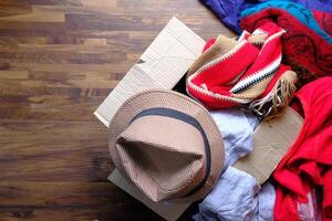 Donation box with donation clothes on a wooden table . photo