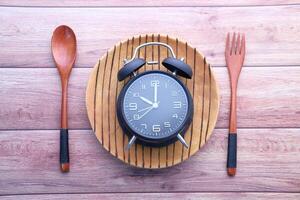 Alarm clock and plate with cutlery, Top view photo