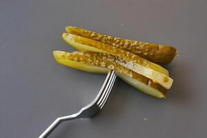 un cerca arriba de un pepinillo en un plato con Tomates foto