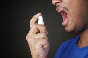 Young Man Applying Fresh Breath Spray photo