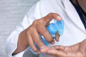 Close up of doctor hand using sanitizer for preventing virus photo