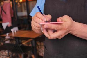 un camarero escritura oder en un cuaderno foto