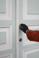 A woman is opening a wooden door photo