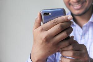 cerca arriba de un contento joven hombre utilizando móvil inteligente teléfono foto